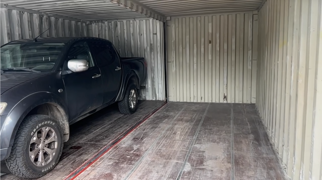 Nissan Navara steht in der Doppelbox, beide Fahrzeugtüren komplett geöffnet