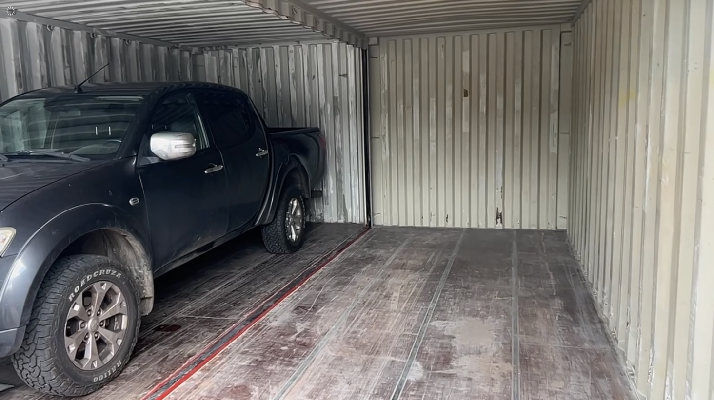 Nissan Navara steht in der Doppelbox, beide Fahrzeugtüren komplett geöffnet