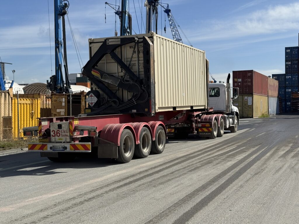 Seitenlader mit einem 20-Fuß-Container auf dem Auflieger